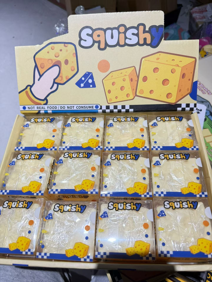 Crunchy cheese cube squishy fidget toy in retail display packaging