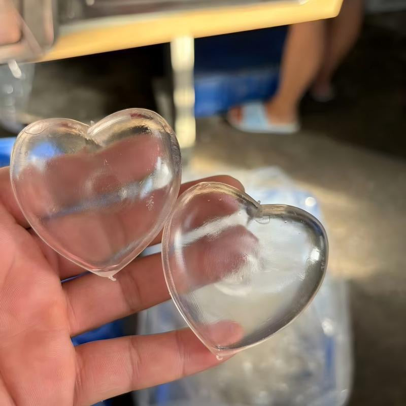 Clear heart-shaped empty squishy skins held in hand