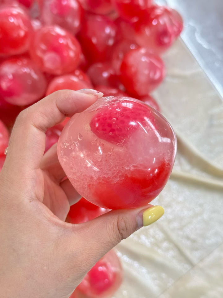 Clear surprise core crystal ball squishy fidget toy held above matching products