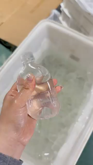 Clear bottle squishy fidget toy compressed around the middle by hand