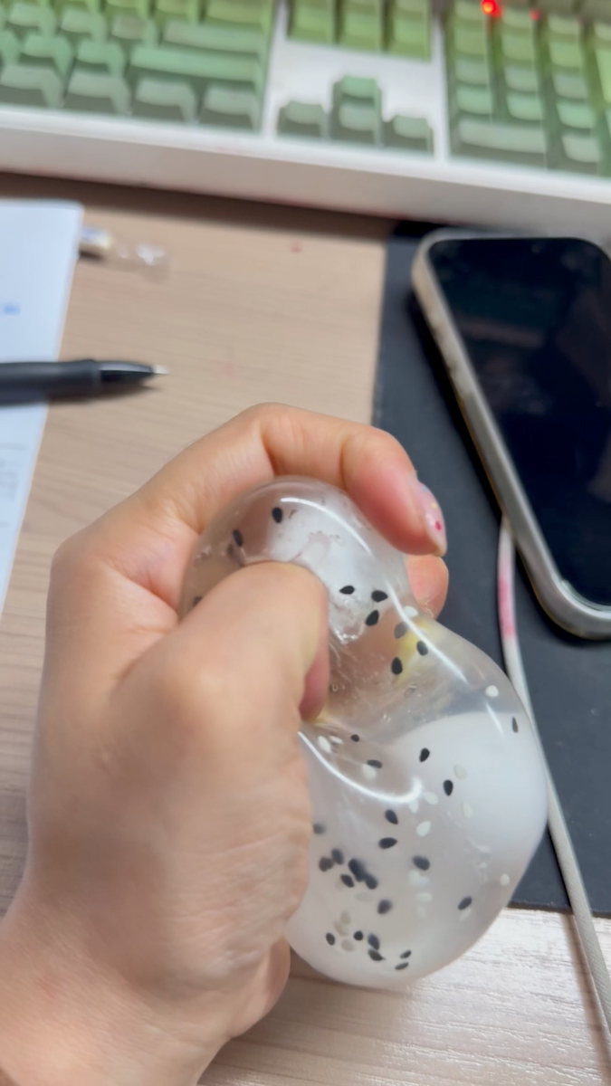 Cracking wax snowball with chia seeds squishy fidget toy being pressed