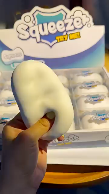 Soft white ring squishy fidget toy pressed through the center by hand