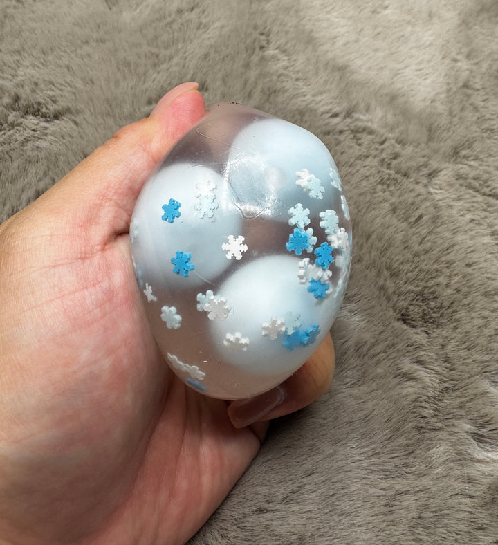 Snow Day clear wax-cracking stress ball with blue and white inserts and snowflakes
